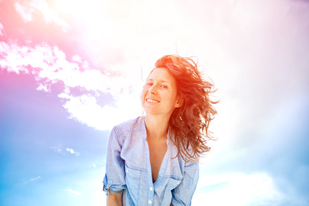woman smiling  against blue sky looking at the camera. Turkey, Antalya.の写真素材