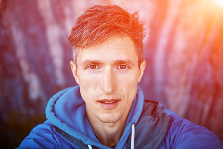 young  man make selfie on the rock backgroundの写真素材
