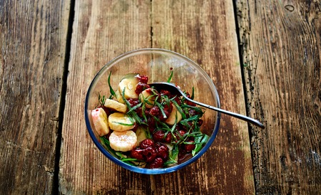salad of fresh bananas, raspberries, estragon and honey in transparent plate on wooden background. Selective focusの写真素材