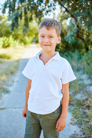 laughing boy looks into the camera in the outdoor over the blue skyの写真素材
