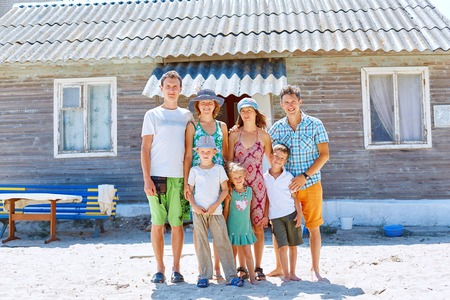 family and friends portret on the beach against bungalow at the  morningの写真素材