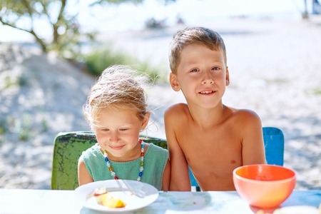 family on the beach having breakfast in sunny dayの写真素材