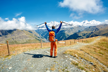 hiker at the top of a pass with backpack enjoy sunny day in Alps. Switzerland, Trek near Matterhorn mount.の写真素材