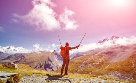 hiker at the top of a pass with backpack enjoy sunny day in Alps. Switzerland, Trek near Matterhorn mount.の写真素材