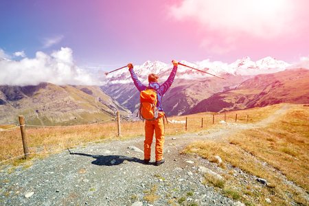 hiker at the top of a pass with backpack enjoy sunny day in Alps. Switzerland, Trek near Matterhorn mount.の写真素材