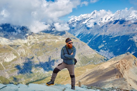 hiker at the top of a pass with backpack enjoy sunny day in Alps. Switzerland, Trek near Matterhorn mount.の写真素材