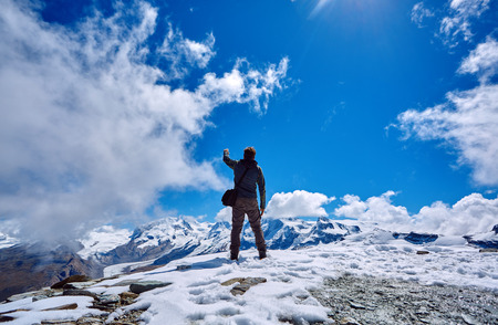 hiker at the top of a pass with backpack enjoy sunny day in Alps. Switzerland, Trek near Matterhorn mount.の写真素材