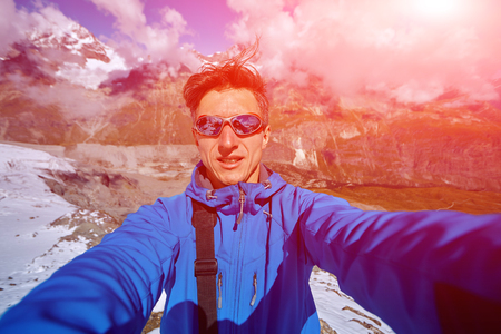 hiker  at the top of a pass  making selfie against  snow capped mountains in Alps. Switzerland, Trek near Matterhorn mount.の写真素材
