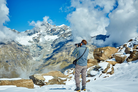 hiker at the top of a pass with camera enjoy sunny day in Alps. Switzerland, Trek near Matterhorn mount.の写真素材