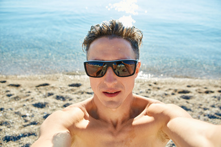 young  man make selfie on the beach.の写真素材