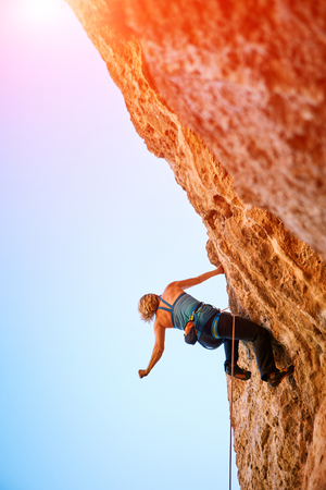 female rock climber climbs on a rocky wallの写真素材