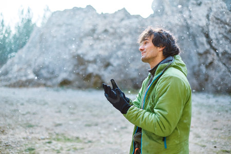 man rock climber preparing to climb under the cliff at winterの写真素材
