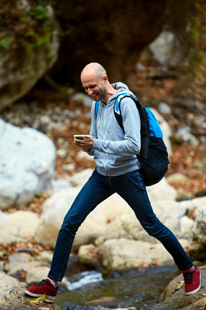 hiker man standing in the woods on the bank of the creekの写真素材