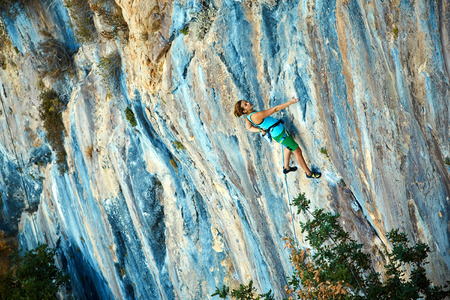 female rock climber climbs on a rocky wallの写真素材