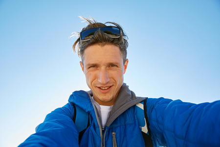young  man make selfiewith blue sky backgroundの写真素材