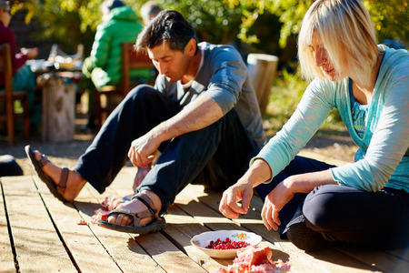 man and woman  in the garden at morning eating pomegranatesの写真素材