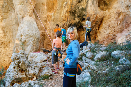 female rock climber stands on a rocky wall background