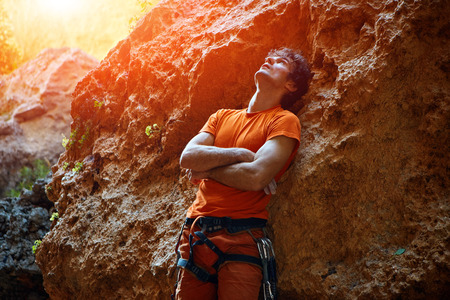male rock climber prepares to climb on a rocky wallの写真素材