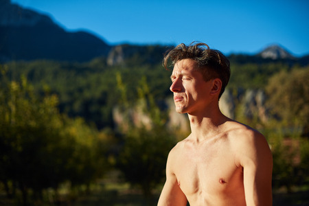 young man doing yoga in the early morning on the garden terrace of the houseの写真素材
