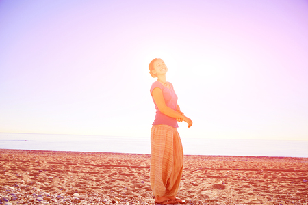 happy attractive  woman looks into the camera on the sunny beach over the blue skyの写真素材