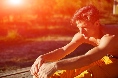 young man doing yoga in the early morning on the garden terrace of the houseの写真素材