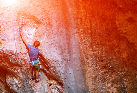 female rock climber climbs on a rocky wallの写真素材