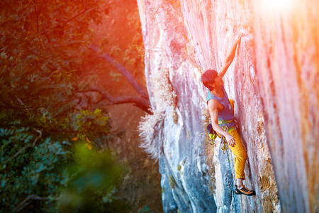 male rock climber climbs on a rocky wallの写真素材