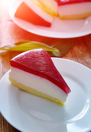 Dietary homemade cakes on a wooden background. sponge cake with cheese mousse and berry jellyの写真素材