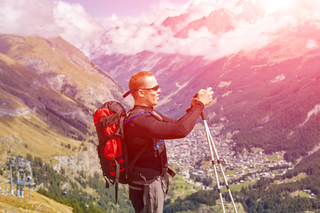 hiker at the top of a pass with camera enjoy sunny day in Alps. Switzerland, Trek near Matterhorn mount.の写真素材