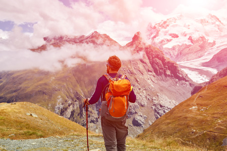 tired hiker with backpack on the trail in the Apls mountains. Trek near Matterhorn mountの写真素材