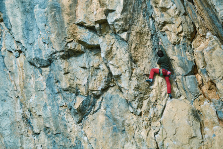 male rock climber climbs on a rocky wallの写真素材