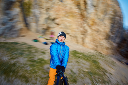 young  man make selfie in the mountains between the rocksの写真素材