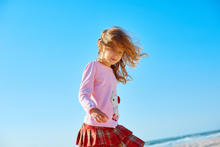 girl walking  on the sunny beach at early morningの写真素材