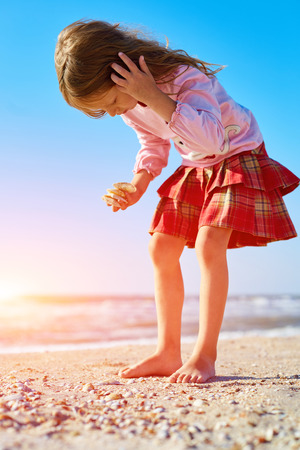 girl walking  on the sunny beach at early morningの写真素材