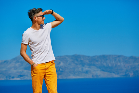 male traveler on the cliff against blue sky and seaの写真素材