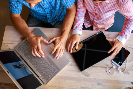 young man and woman with laptop typing on the keyboard in cafe. palm, tablet PC and laptop closeup