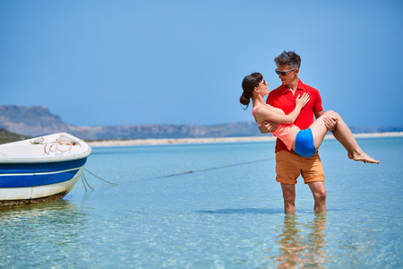 couple standing in the sea  near the boat.の写真素材
