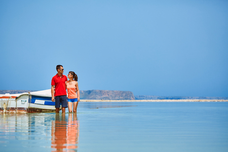couple standing in the sea near the boat.の写真素材