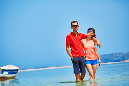 couple standing in the sea near the boat.の写真素材