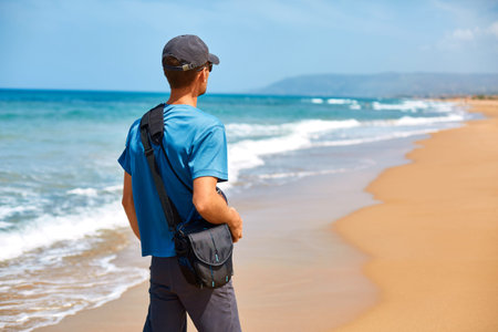 man walking on the empty sunny beach, Crete, Greece