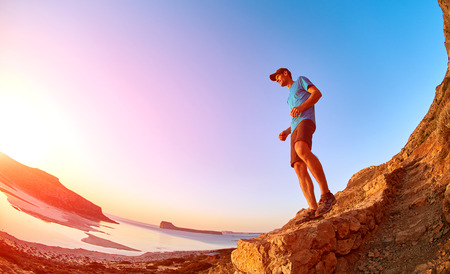 male hiker, traveler on the trail against sea and blue sky at the sunset. Balos beach on background, Crete, Greeceの写真素材