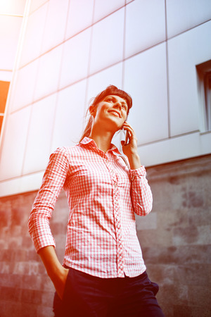 young woman with phone standing outdoor. Lifestyle or business conceptの写真素材