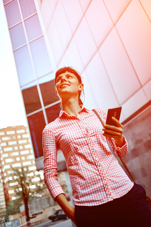young woman with phone standing outdoor. Lifestyle or business conceptの写真素材