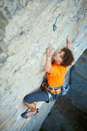 male rock climber. rock climber climbs on a rocky wall. man makes hard moveの写真素材