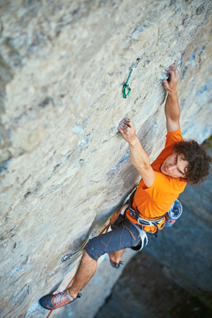 male rock climber. rock climber climbs on a rocky wall. focus on the handの写真素材