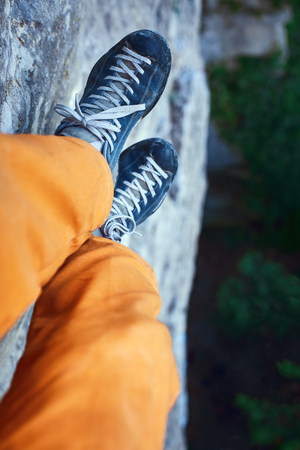 close-up legs and feet of climber. man hanging on a rope over the treesの写真素材