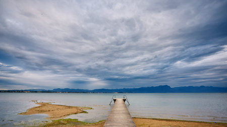 lake and small pier for boats and cloudy sky