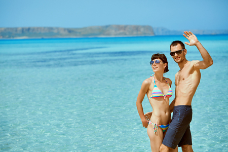 young happy couple in love walking on the beach at the sunny day. Balos beach, Crete, Greece. newlyweds in a honeymoon on the sea and islandsの写真素材