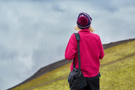 woman hiker photographer taking picture on the lake background in Icelandの写真素材