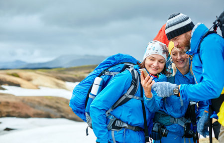 couple friends hikers un the Islandic mountains. two woman and one man photographer taking picture...